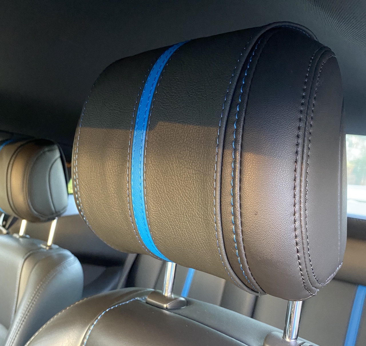 Custom black headrest cover with a single blue stripe down the middle